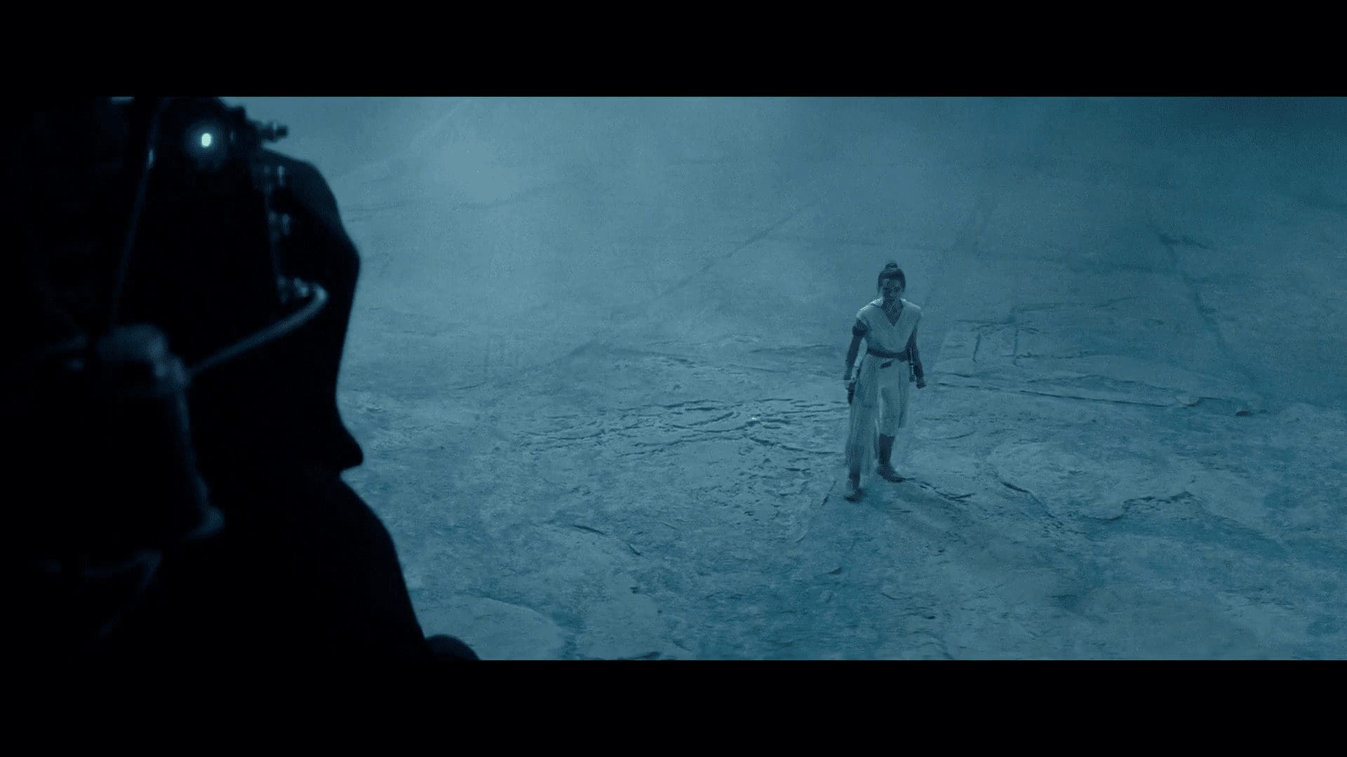 A cloaked figure on a mechanical rig approaching Rey—Palpatine?
