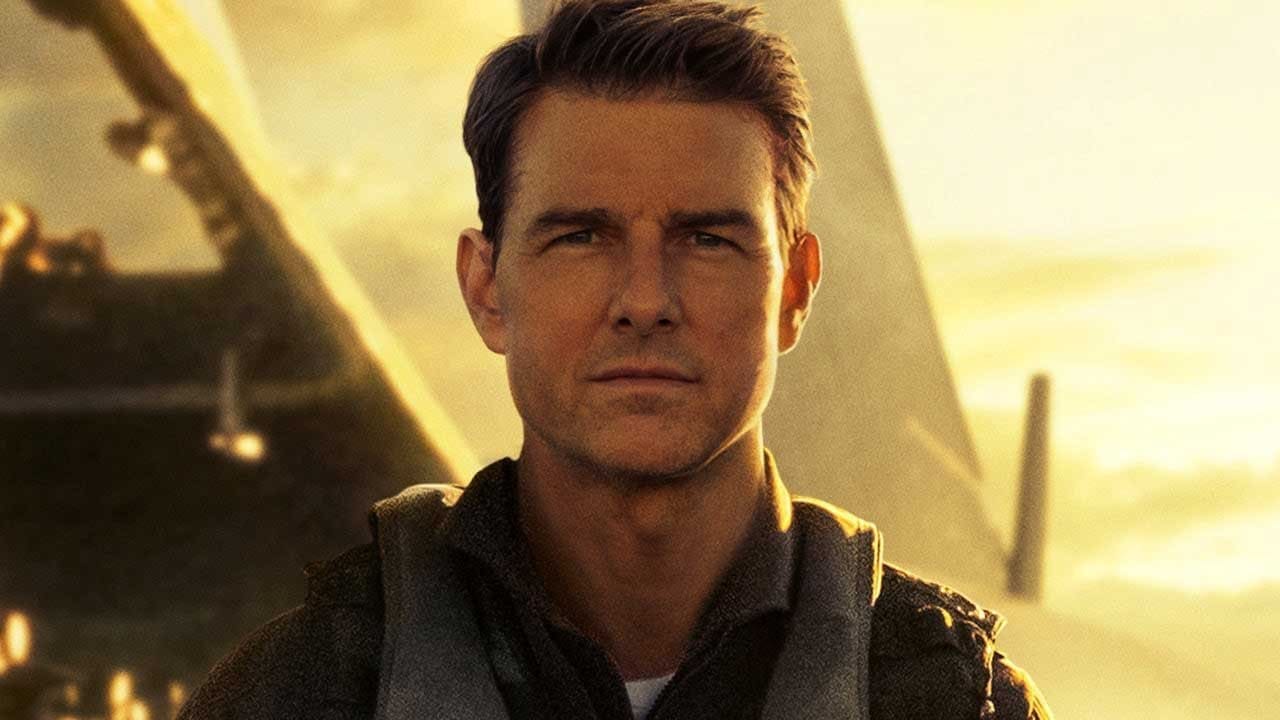 Tom Cruise as Maverick standing beside a fighter jet